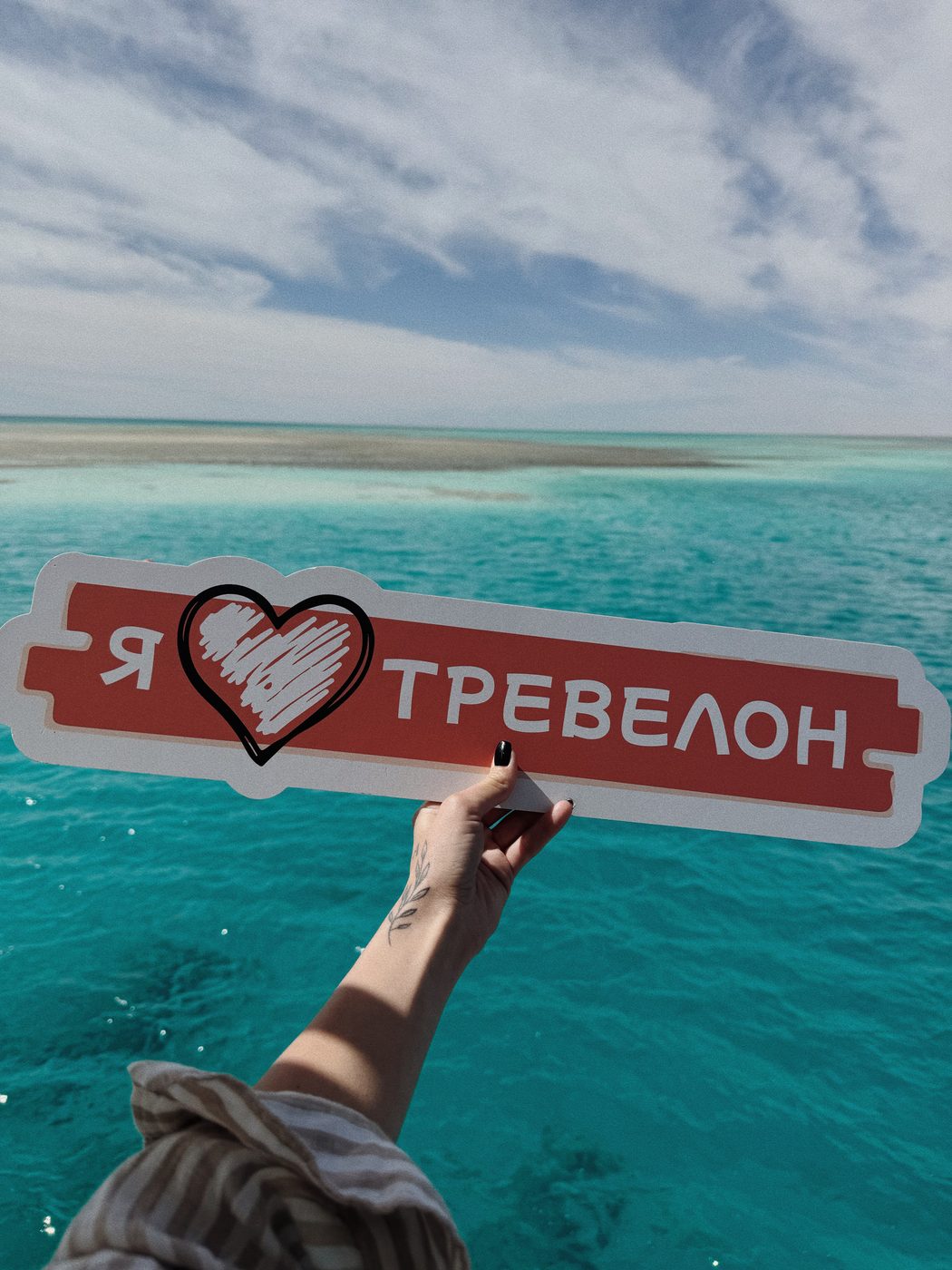Табличка «Я люблю Тревелон» на тлі бірюзового моря — з катера в одному з попередніх Мама-турів